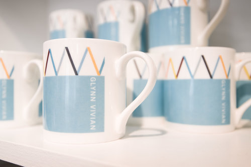 Image of mugs with Glynn Vivian branding. Items on sale in the Glynn Vivian Art Gallery shop. Photo © Polly Thomas