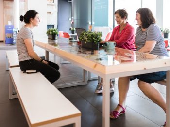 Three customers sitting on benches at a table at the Glynn Vivian Art Gallery cafe. Photo © Polly Thomas