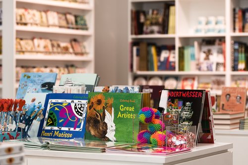 Shop table with illustrated books about great artists and art and other items to purchase from the Glynn Vivian Art Gallery shop
