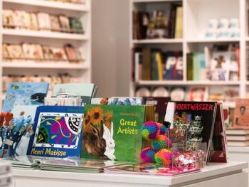 Shop table with illustrated books about great artists and art and other items to purchase from the Glynn Vivian Art Gallery shop