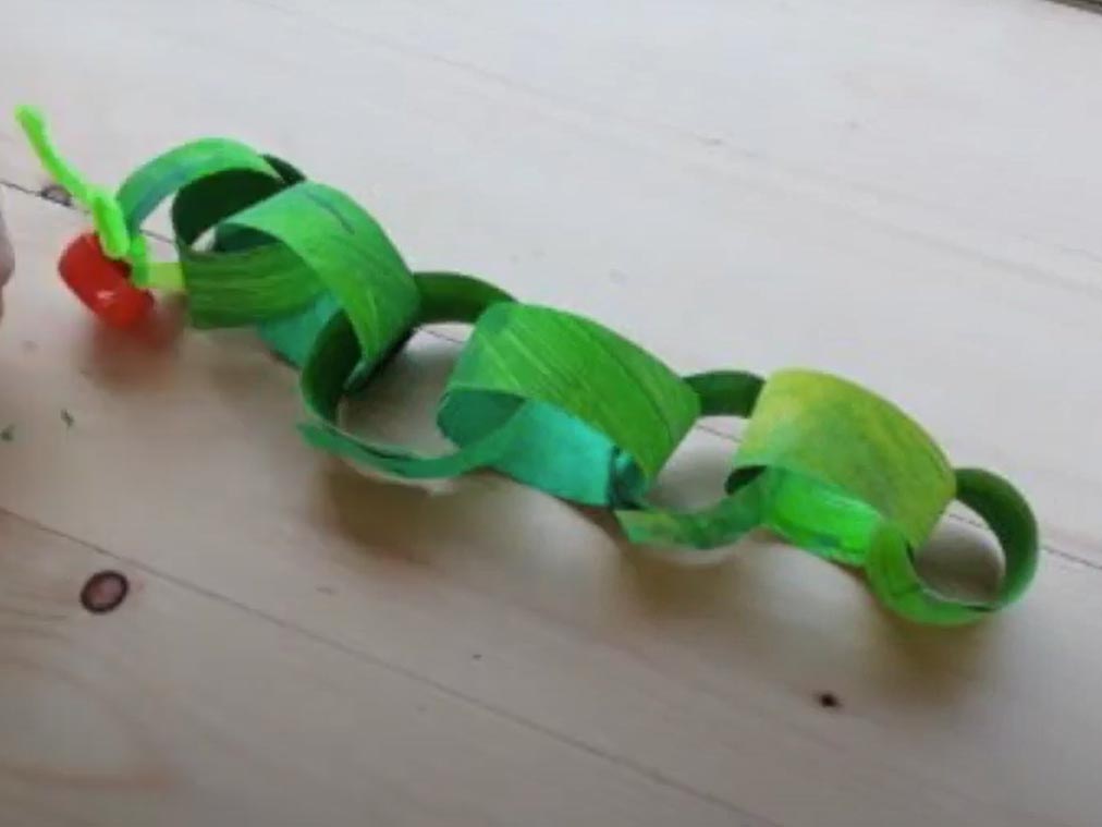 An images of a green paper chain made into a caterpillar