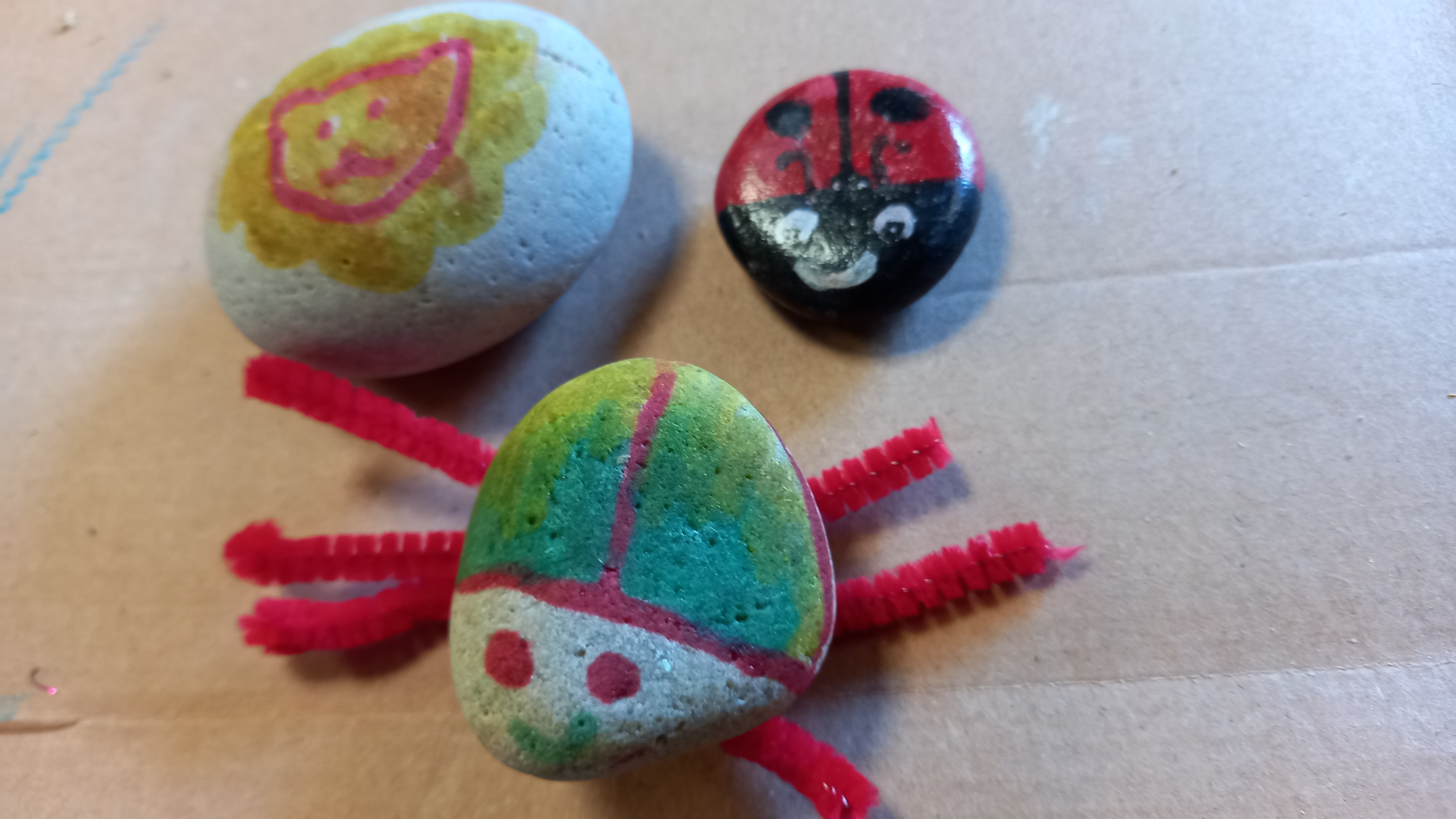 three pebbles that have painted to look like garden bugs