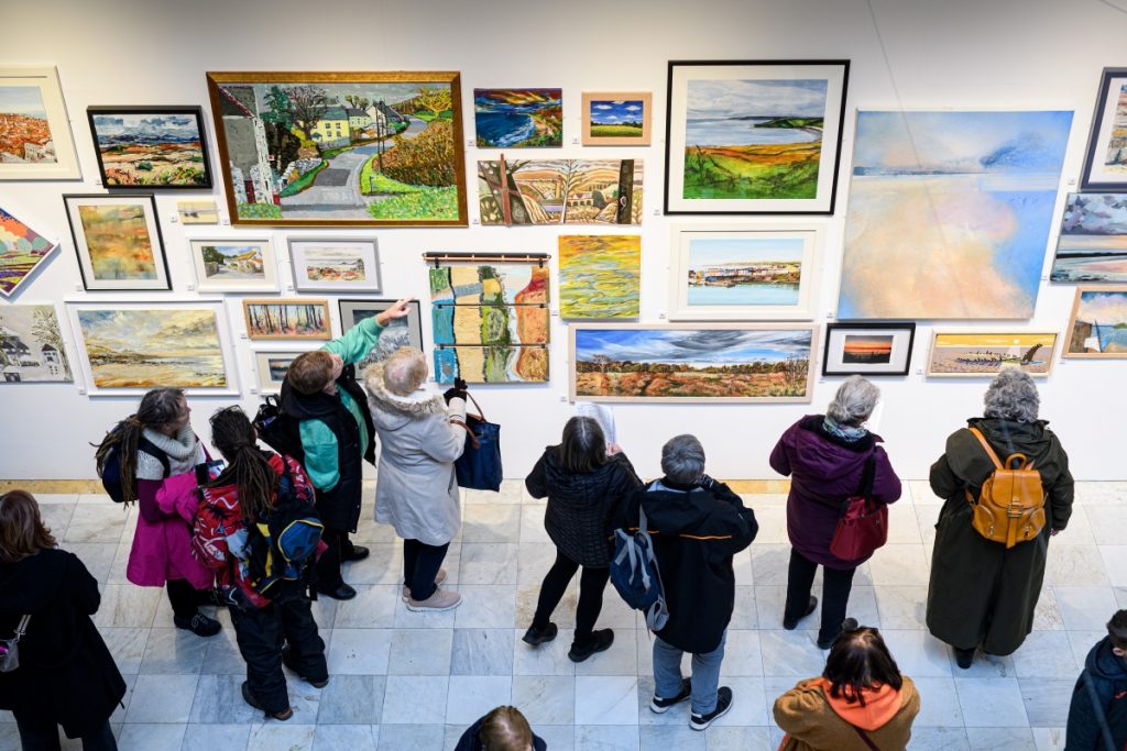 Gallery view of paintings on a large wall